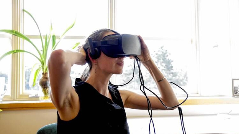 A woman wears a virtual reality mask.