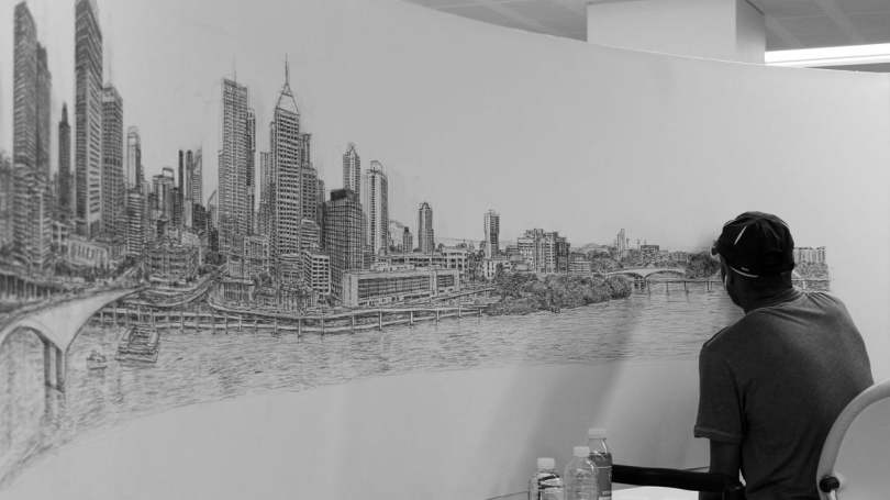 A person draws a black and white mural.